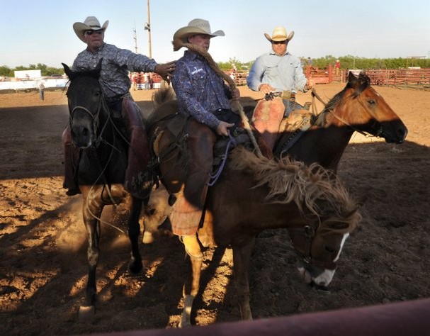 Photo Credit: Ronald W. Erdrich/Reporter-News Cody Aaron (left) reaches out to Cody Heck as he and pickup man Jeff Flowers ride in behind during the ranch bronc riding event at the Wild Horse Prairie Days rodeo Friday in Haskell, June 7, 2013. (Big Country Journal)